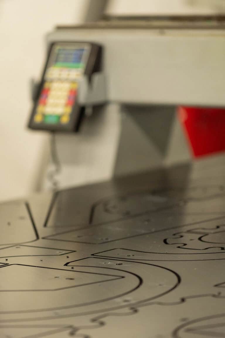 Blurred control panel and metal cutting table with etched pattern outlines